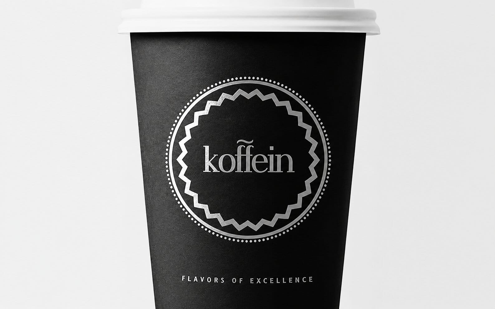 Black takeaway cup with the Koffein roundel stamp in silver foil
